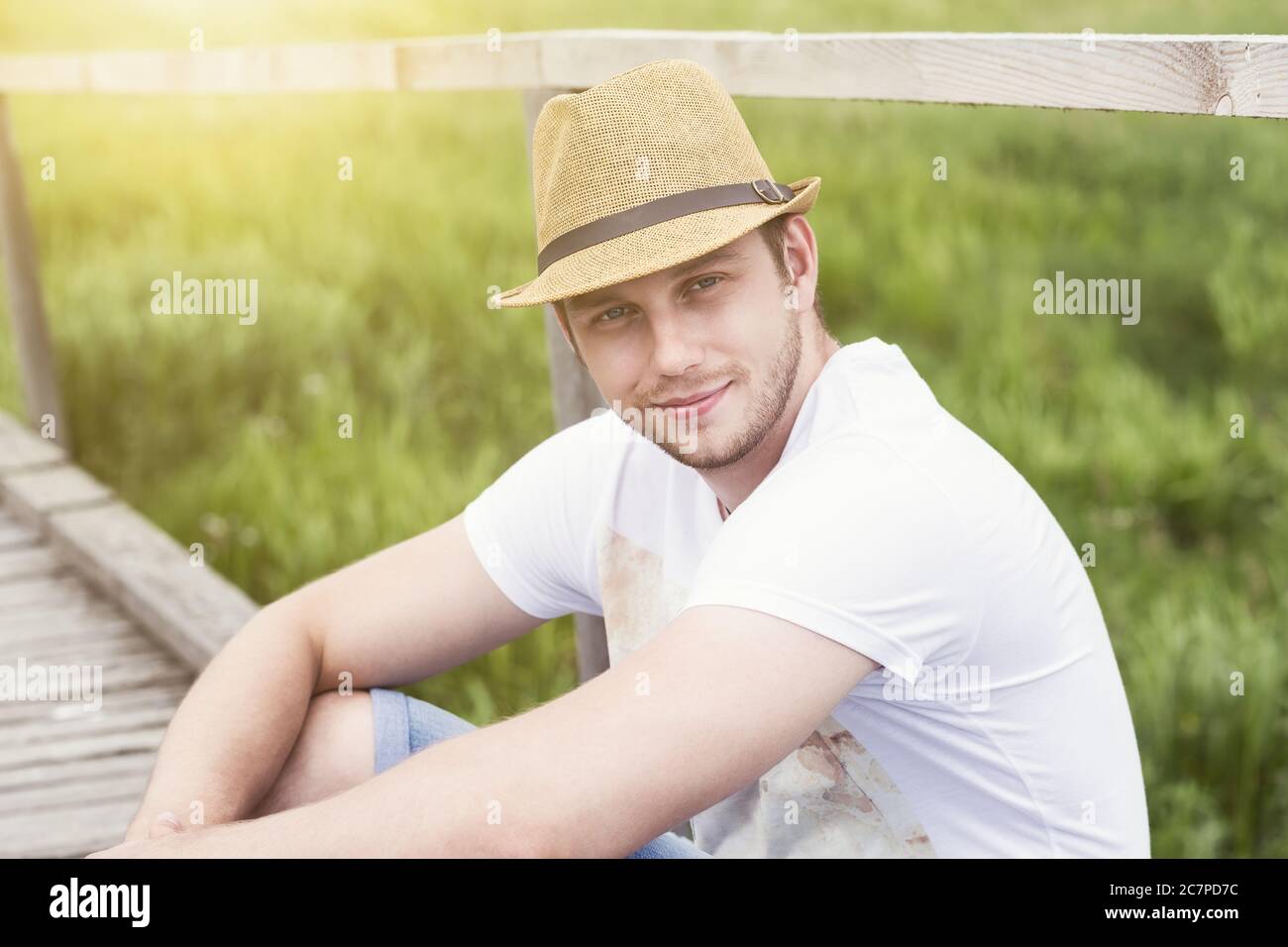 Close up portrait of smiling handsome man sitting outdoor Stock Photo