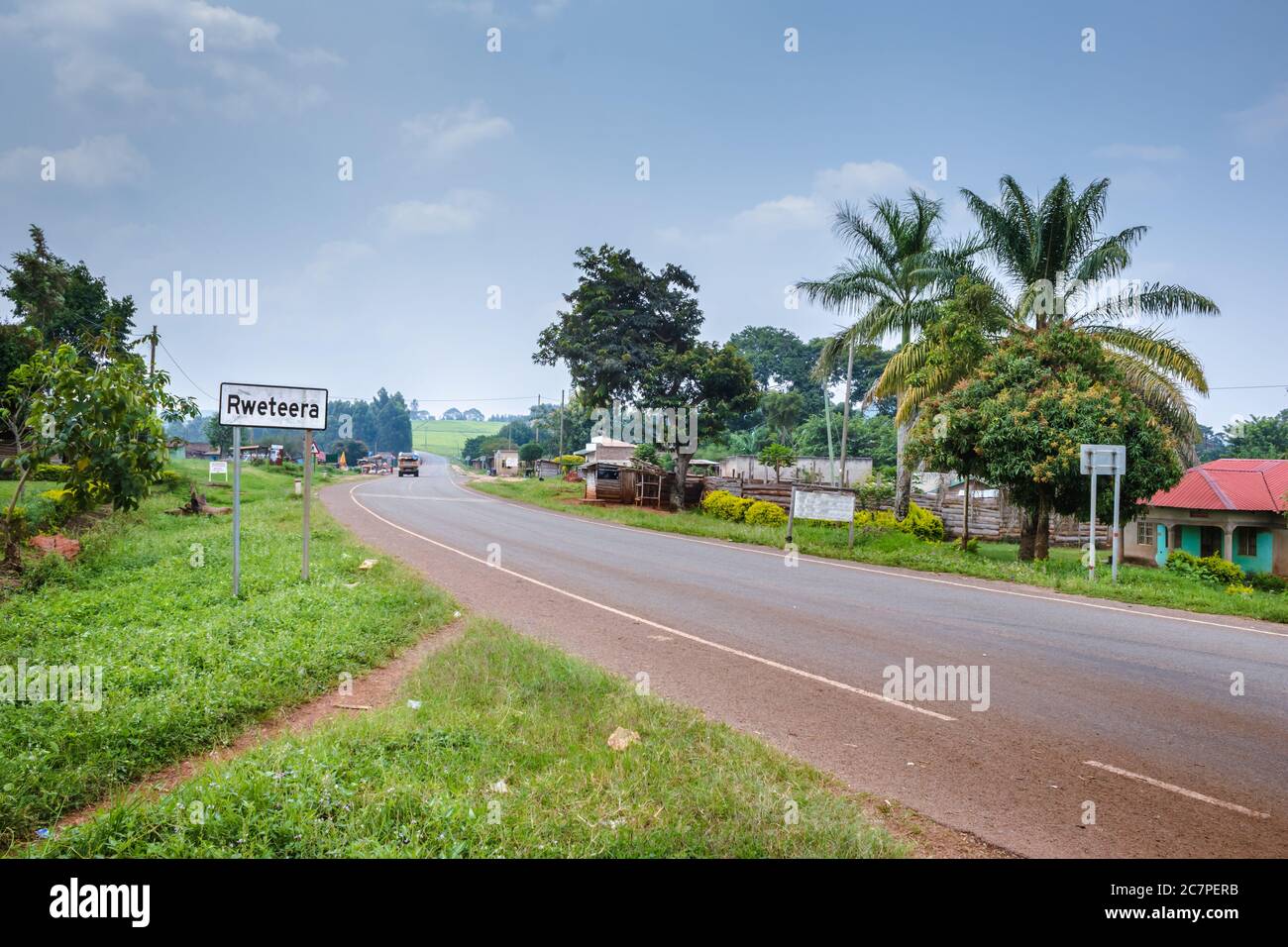 View of a road passing through a small town with house’s and vehicles