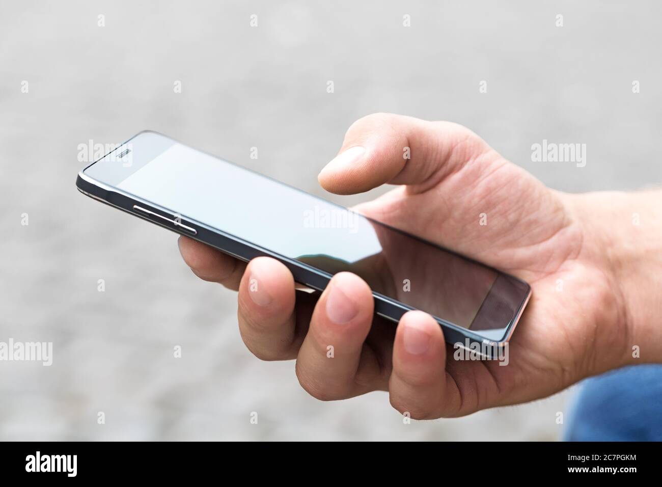 Man using his Mobile Phone outdoor, close up Stock Photo