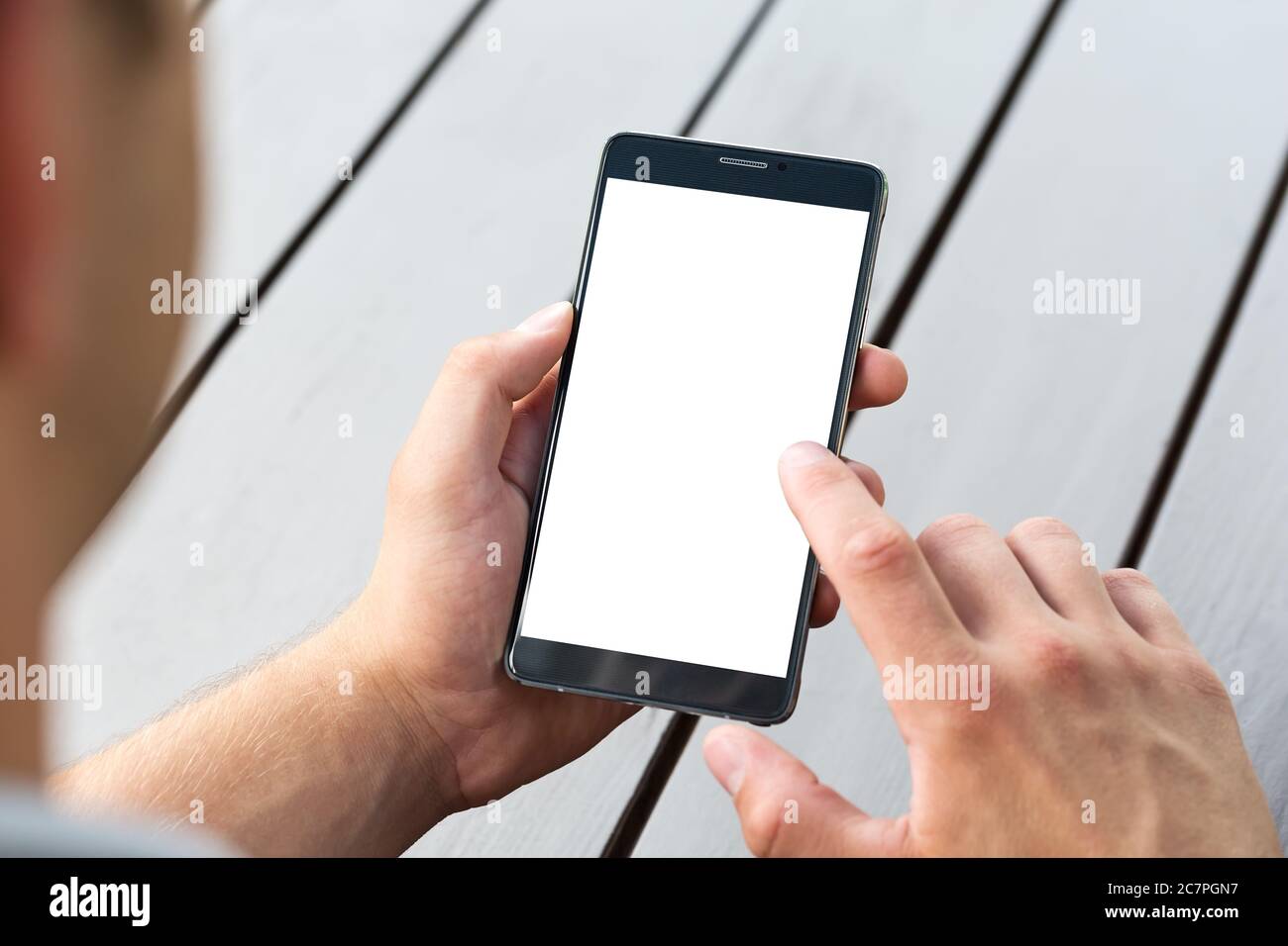 Man holding smart mobile phone on wooden table background Stock Photo