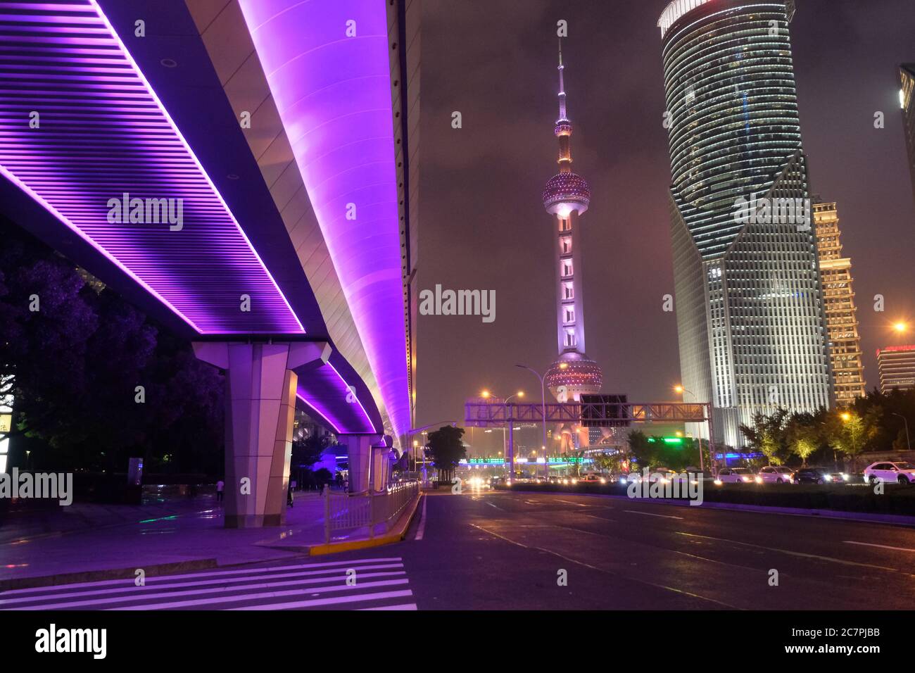 night scene of modern Shanghai Pudong. Highway under shining purple overpass. Famous Oriental Pearl TV Tower and buildings Stock Photo