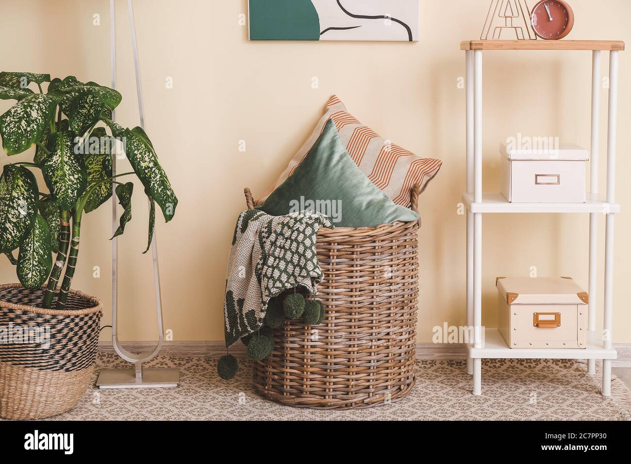 Basket with pillows and plaid in room Stock Photo Alamy