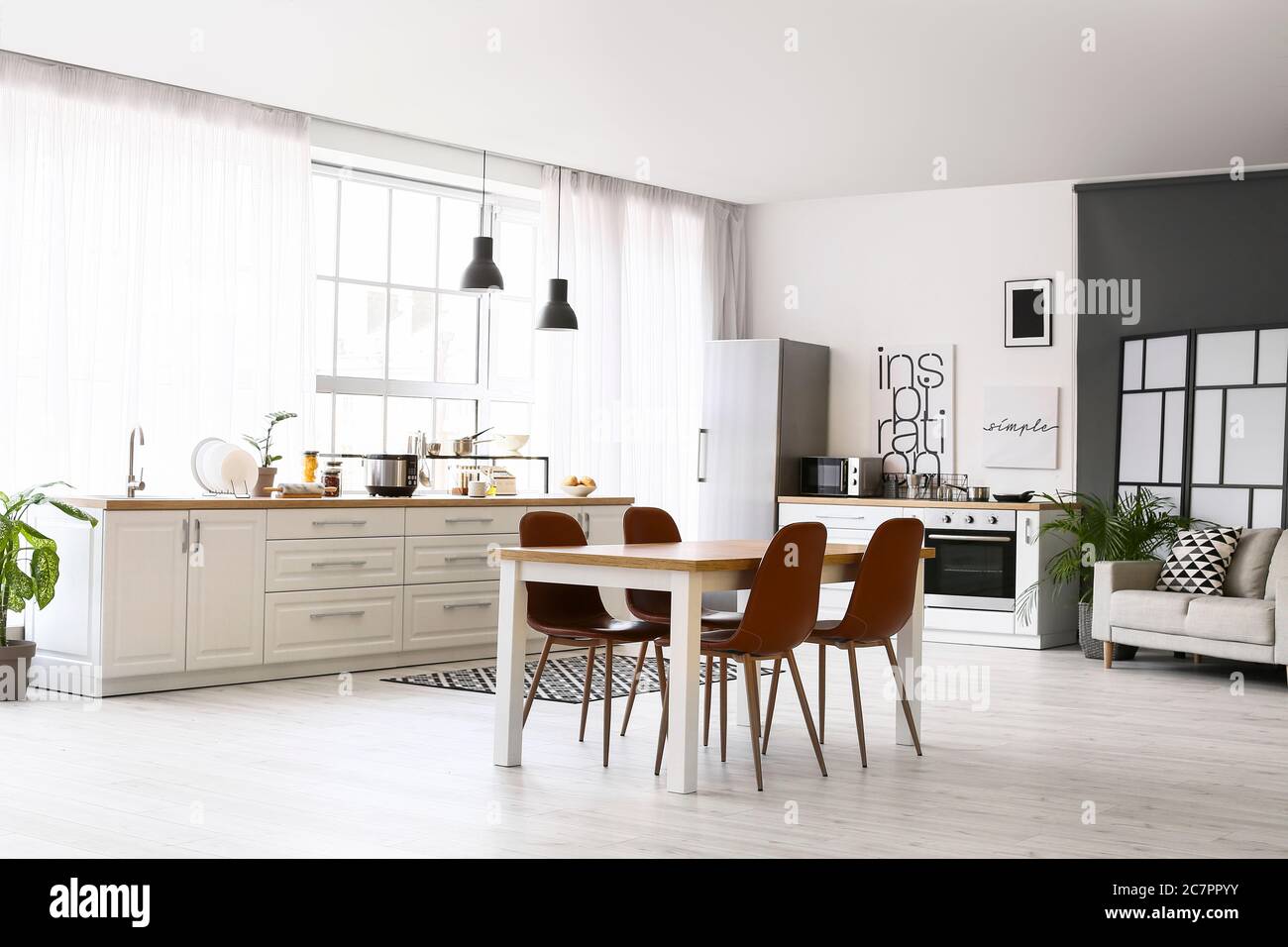 Stylish interior of modern kitchen with dining table Stock Photo - Alamy