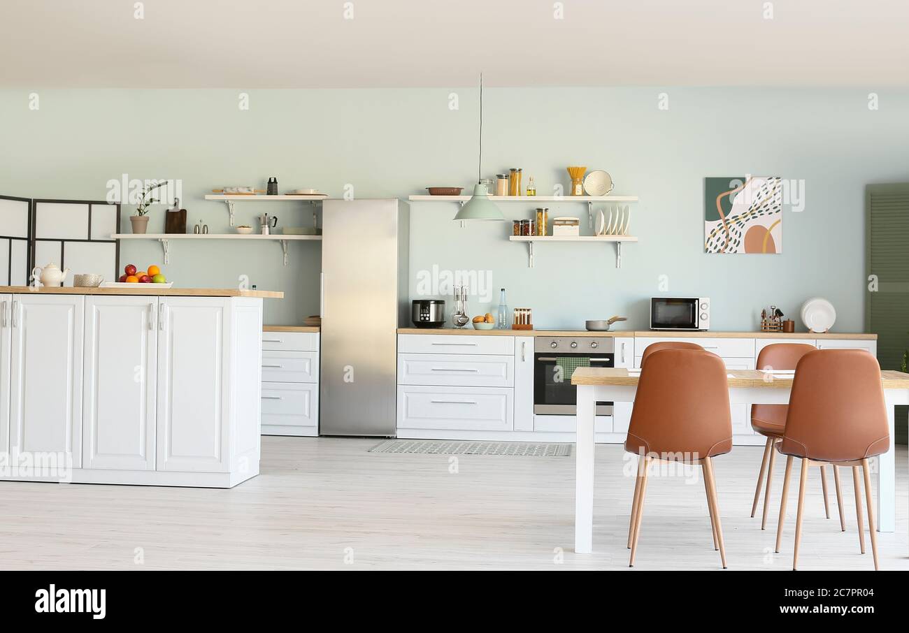 Stylish interior of modern kitchen with dining table Stock Photo - Alamy