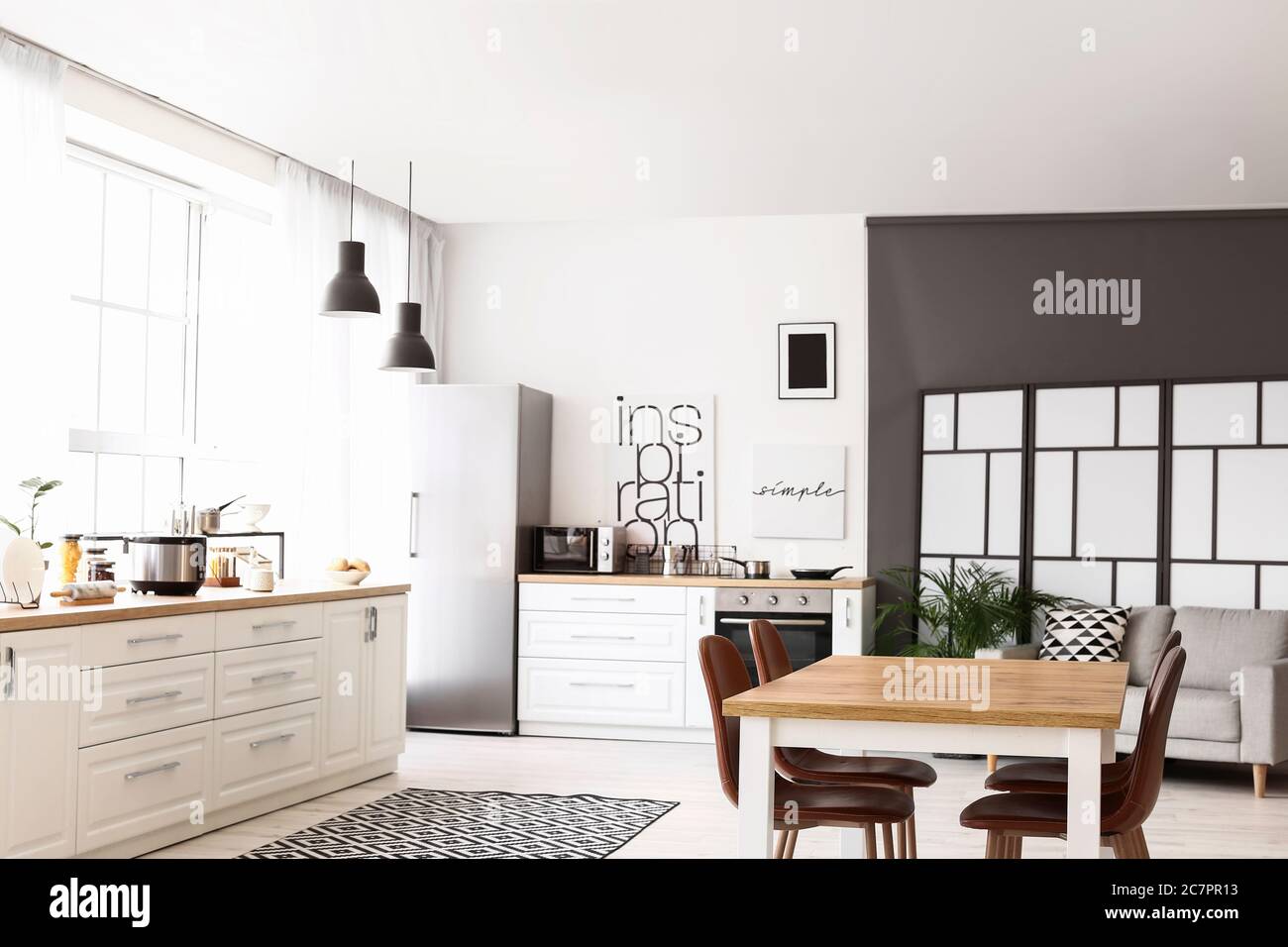Stylish interior of modern kitchen with dining table Stock Photo - Alamy