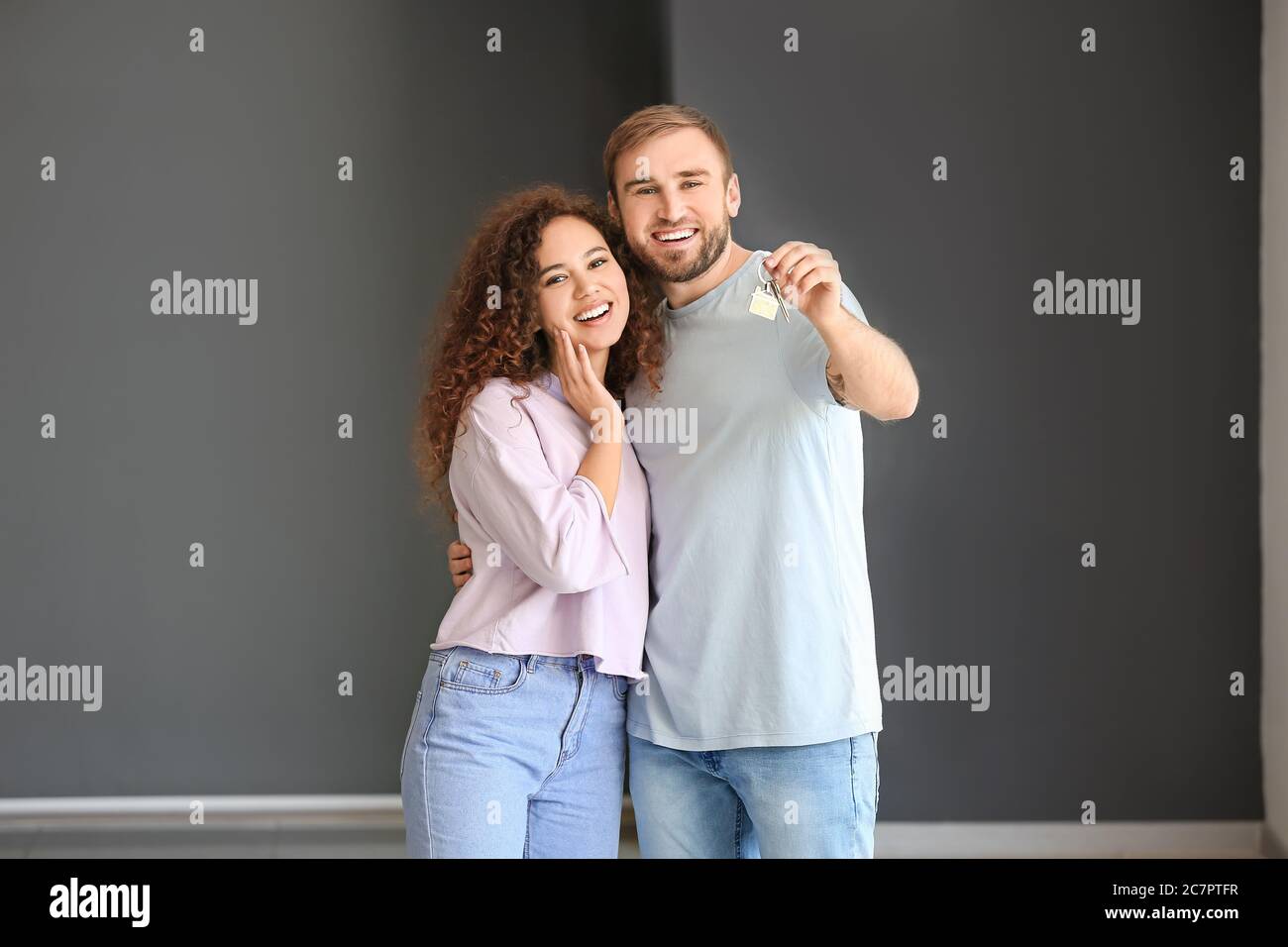 Happy young couple with key in their new flat Stock Photo - Alamy