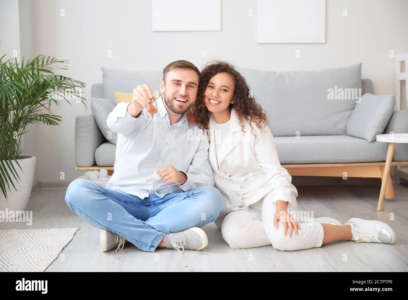 Happy young couple with key in their new flat Stock Photo - Alamy