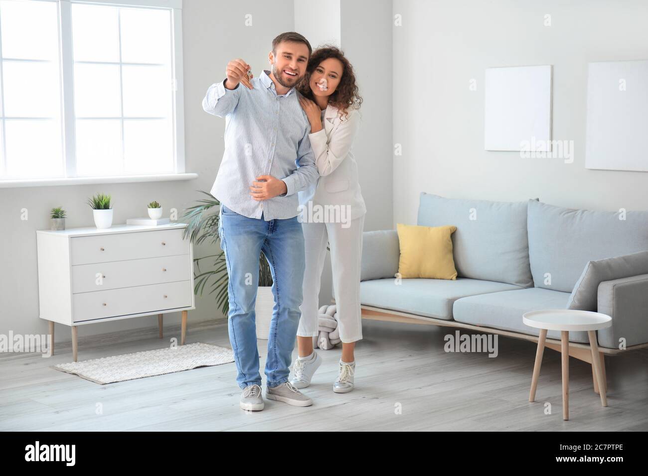 Happy young couple with key in their new flat Stock Photo - Alamy