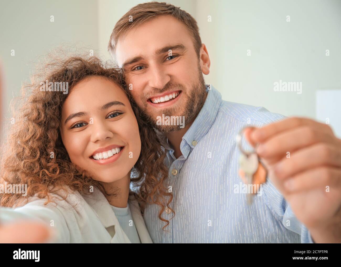 Happy young couple with key in their new flat Stock Photo - Alamy