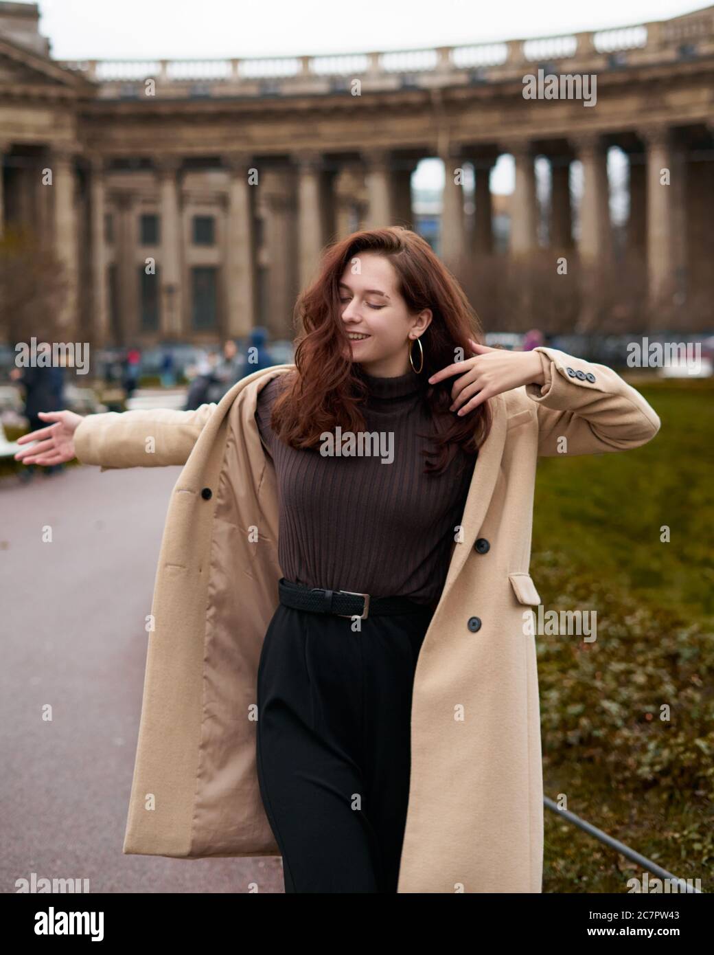 Beautiful funny naughty stylish fashionable happy girl dancing on streets  of St. Petersburg city. Charming smiling woman with long dark hair, vertical  Stock Photo - Alamy