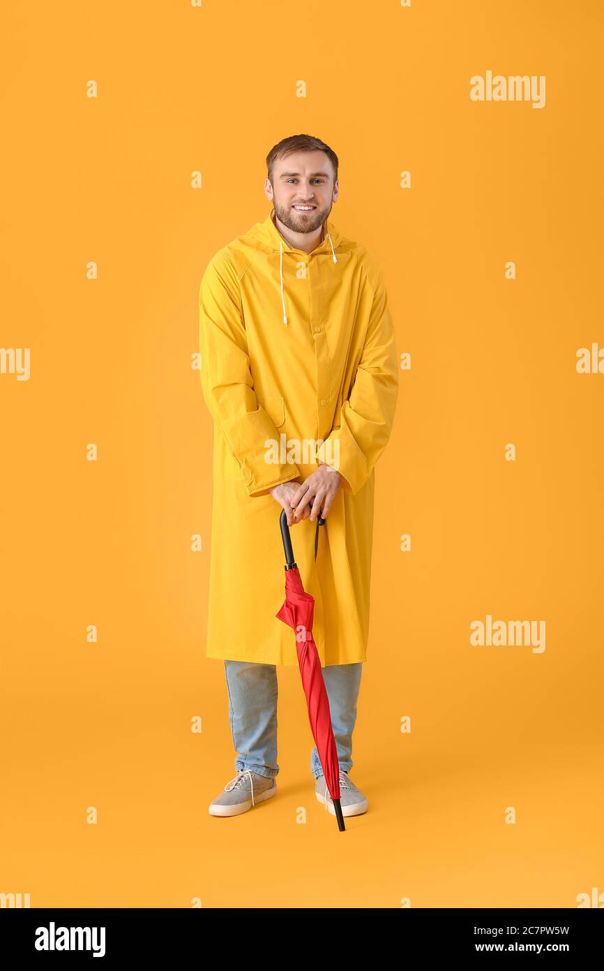 Handsome young man with umbrella on color background Stock Photo - Alamy