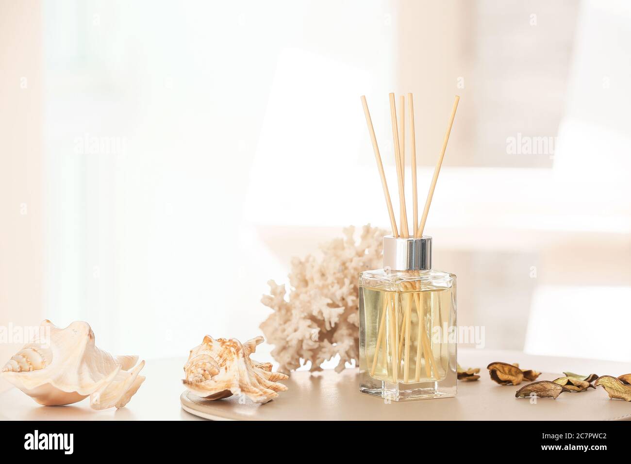 Reed diffuser and sea shells on table in room Stock Photo Alamy