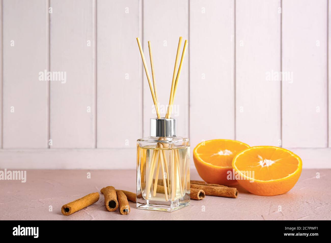 Reed diffuser, orange and cinnamon on table in room Stock Photo