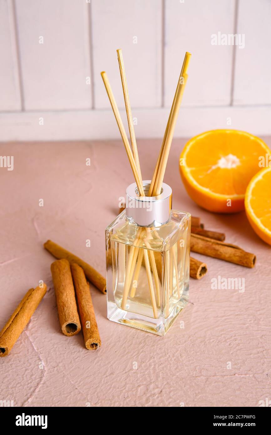 Reed diffuser, orange and cinnamon on table in room Stock Photo