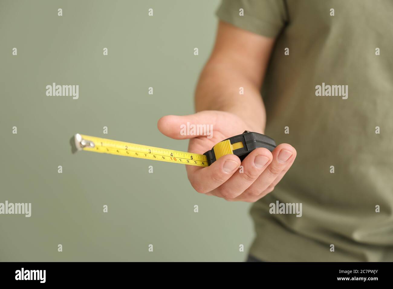 https://c8.alamy.com/comp/2C7PWJY/male-worker-with-tape-measure-on-color-background-closeup-2C7PWJY.jpg