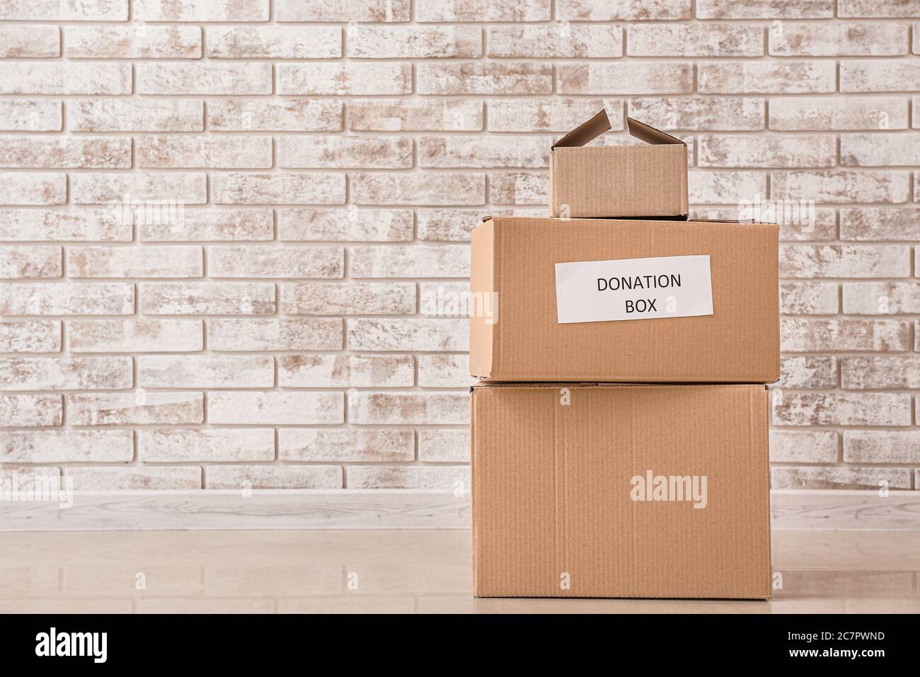 Boxes with donations on floor near brick wall Stock Photo Alamy