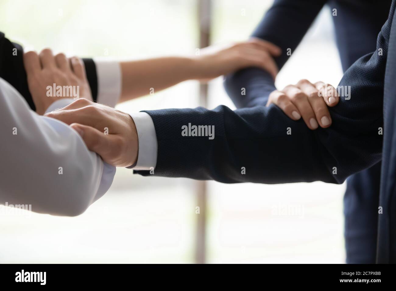 Businesspeople standing shoulder by shoulder showing unity closeup image Stock Photo