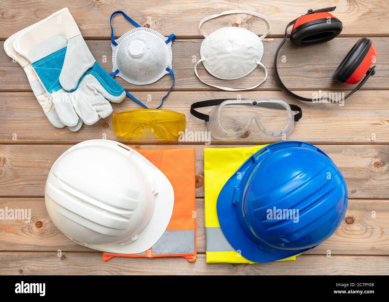 Work safety protection equipment. Industrial protective gear for two on wooden background. Construction site health and safety concept Stock Photo