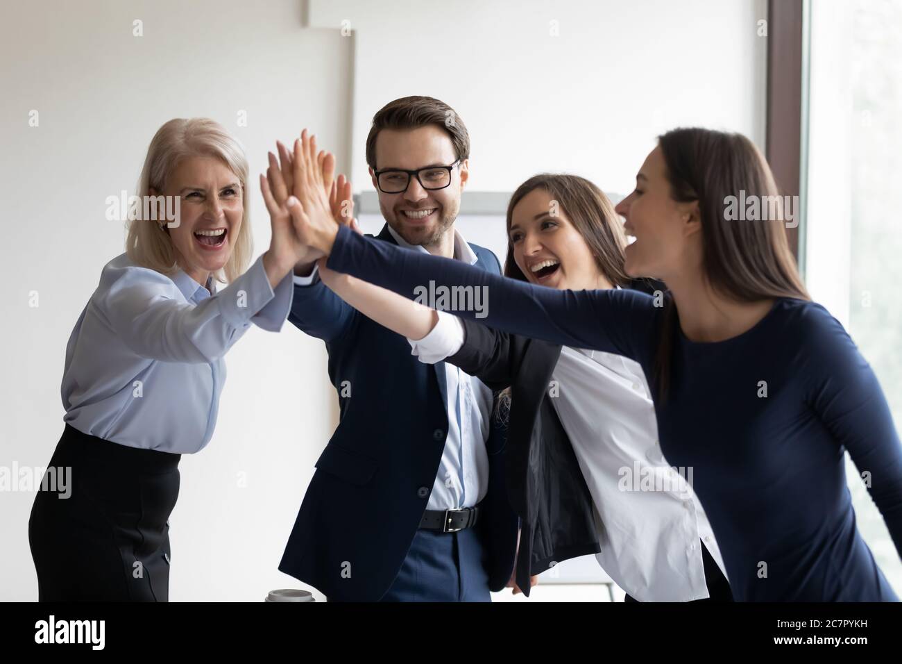 Happy multiethnic staff give high five celebrating achievement Stock Photo