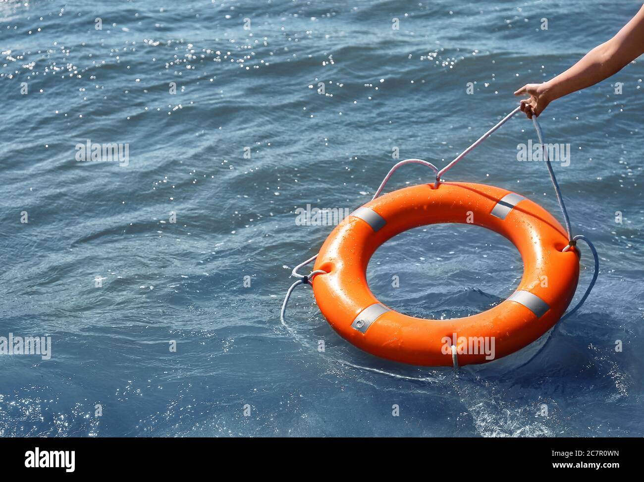 Woman throwing lifebuoy ring on water Stock Photo Alamy