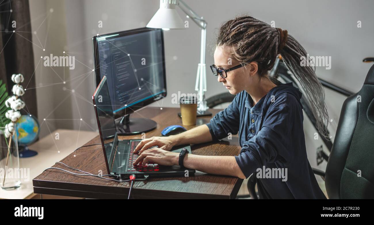 Modern young female programmer is writing program code on a laptop at ...