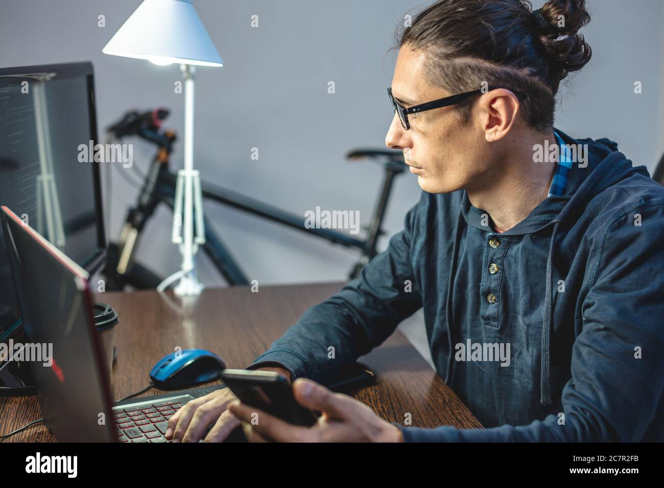 Male programmer is writing program code on a laptop at home. Remote work in the IT profession. The concept of software development. Stock Photo