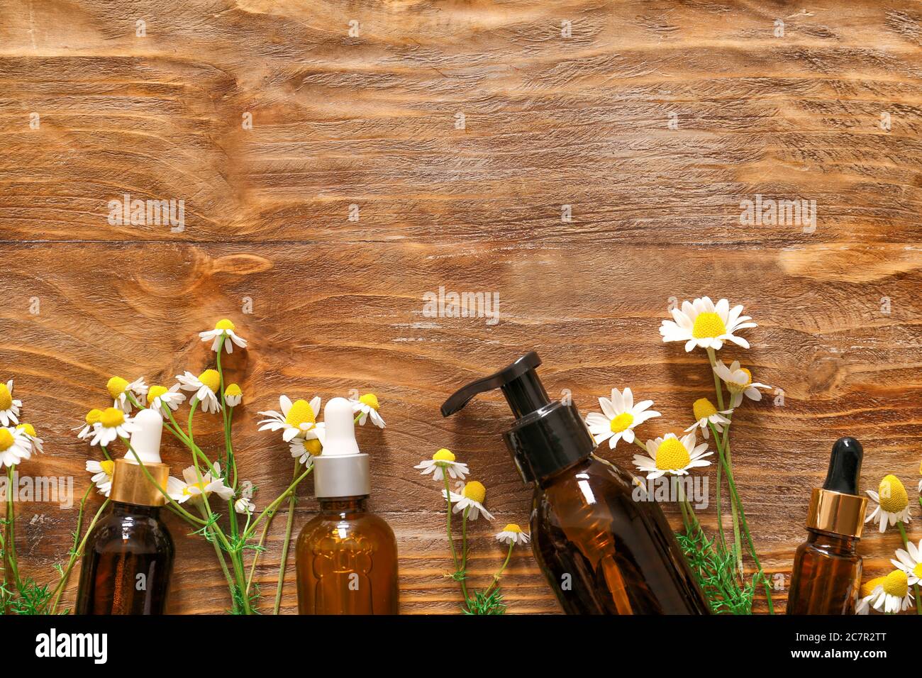 Cosmetics with chamomile flowers on wooden background Stock Photo