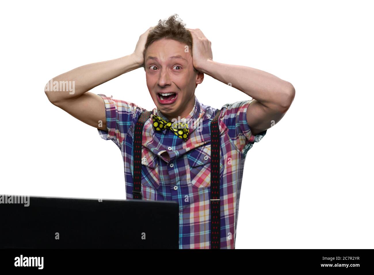 Extremely stressed and desperated teenage boy in front of a computer ...