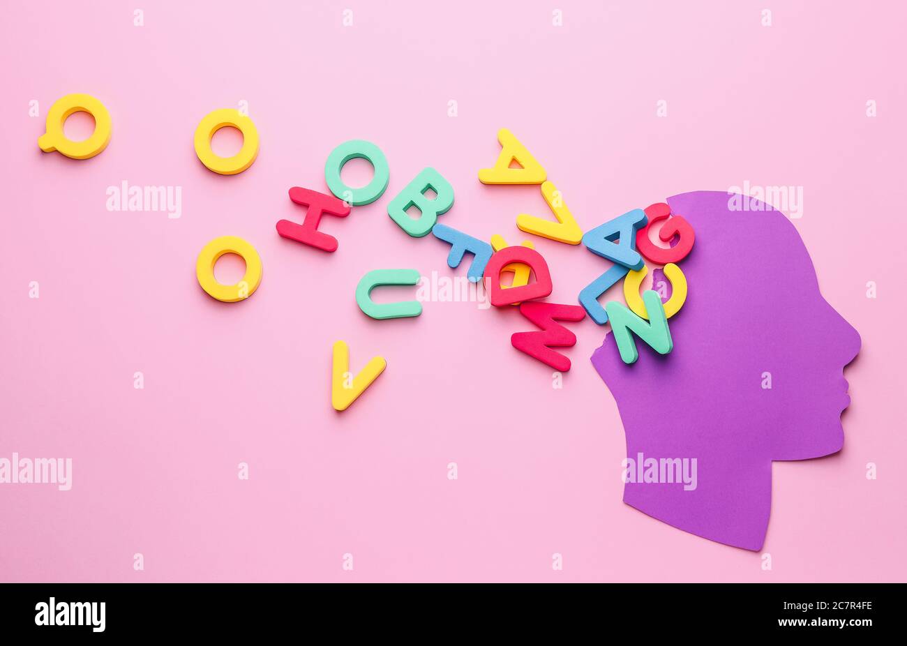Paper human head with letters on color background. Dyslexia concept
