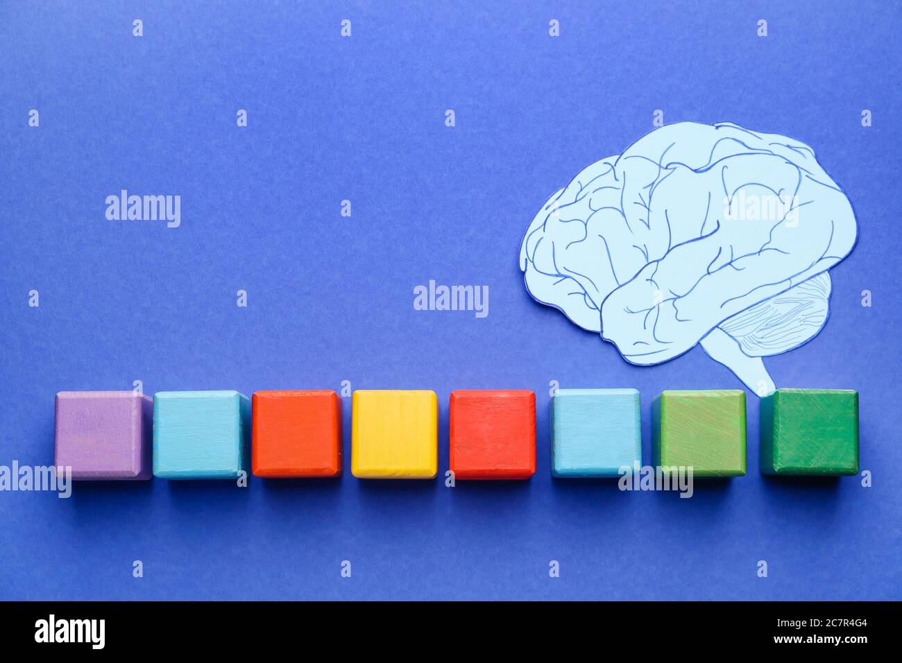 Cubes and paper brain on color background. Dyslexia concept Stock Photo
