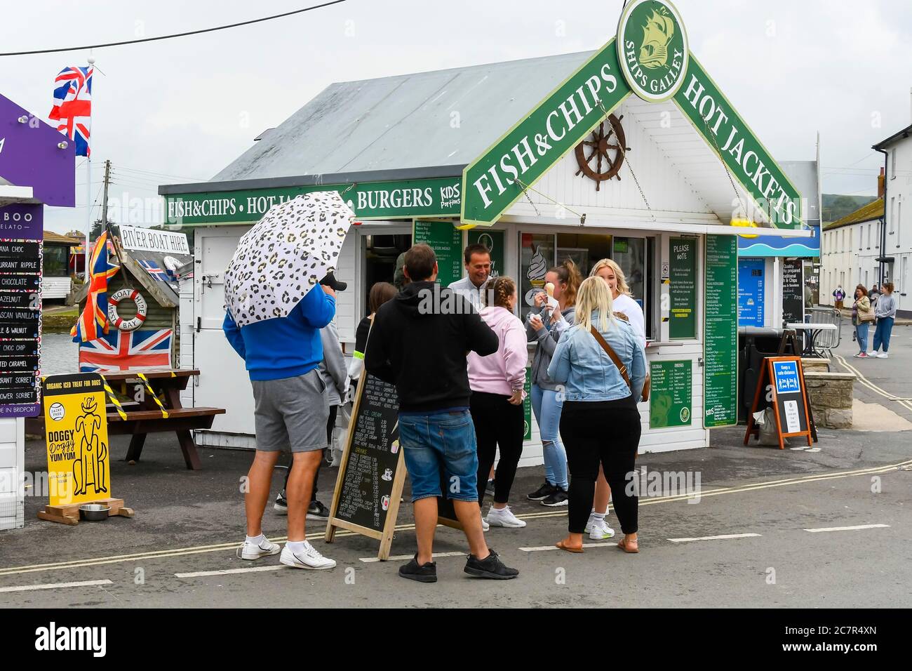 West Bay, Dorset, UK. 19th July 2020. UK Weather. Visitors standing