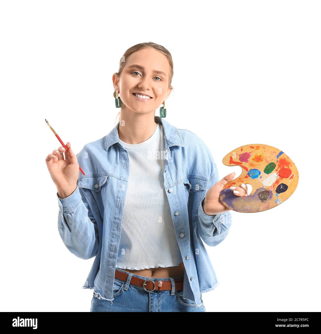Beautiful young woman with paint palette and brush on white background ...