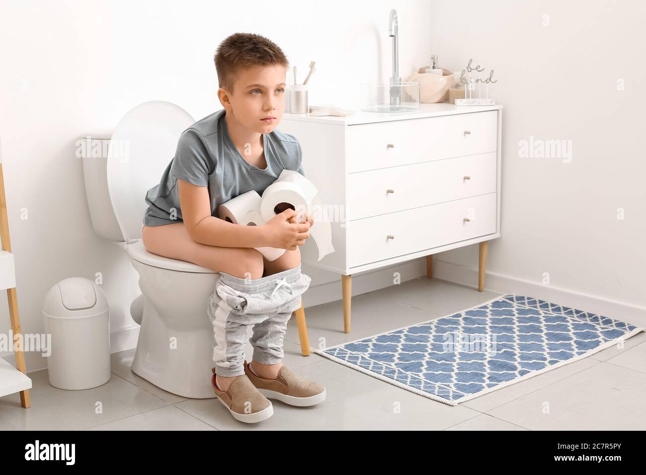 Little boy sitting on toilet bowl in restroom Stock Photo Alamy