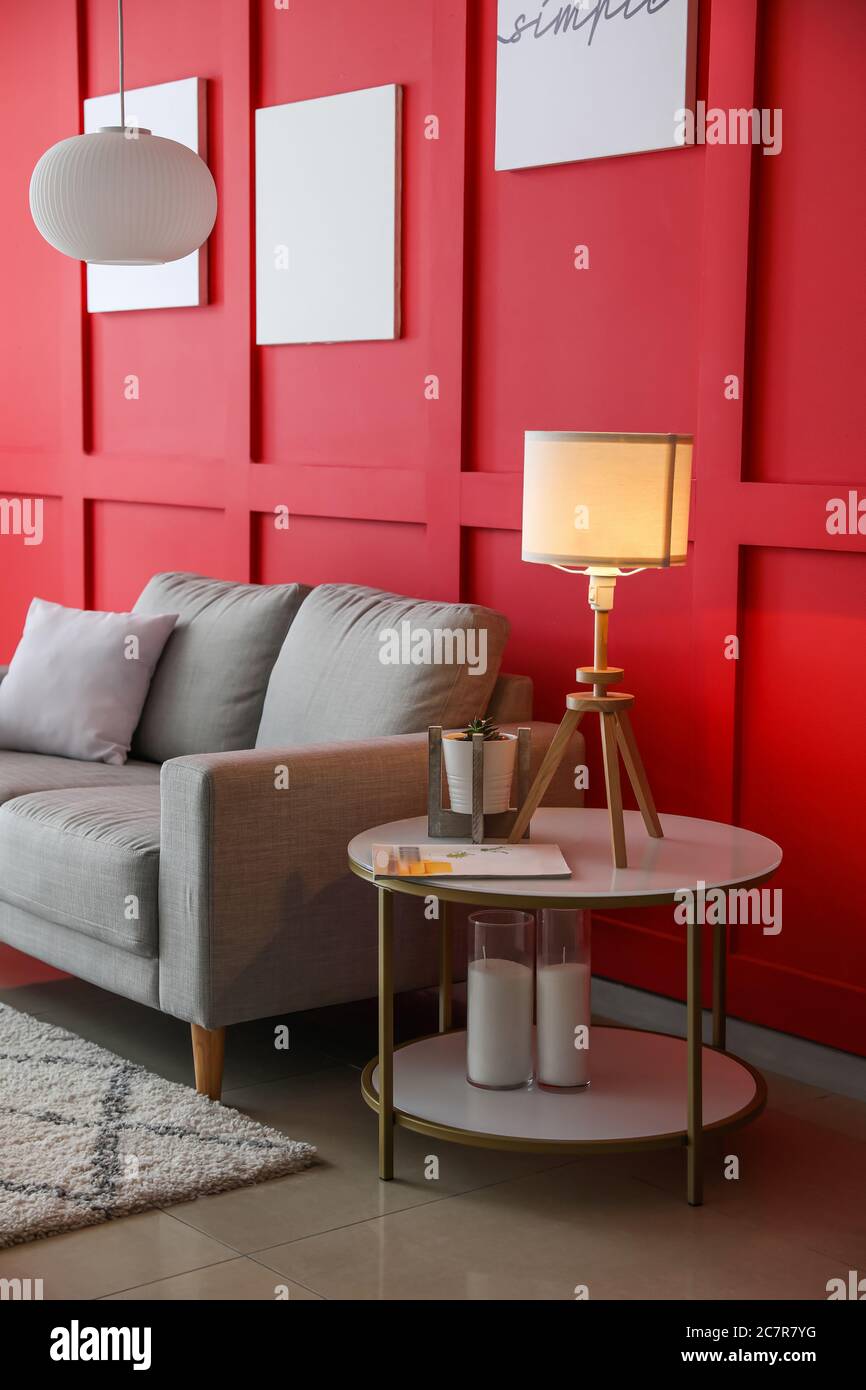 Stylish interior of living room with sofa, table and lamp Stock Photo ...