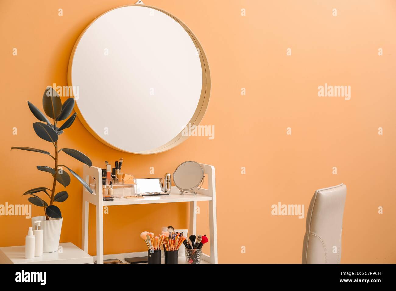 Rack with decorative cosmetics and mirror in modern makeup room Stock Photo
