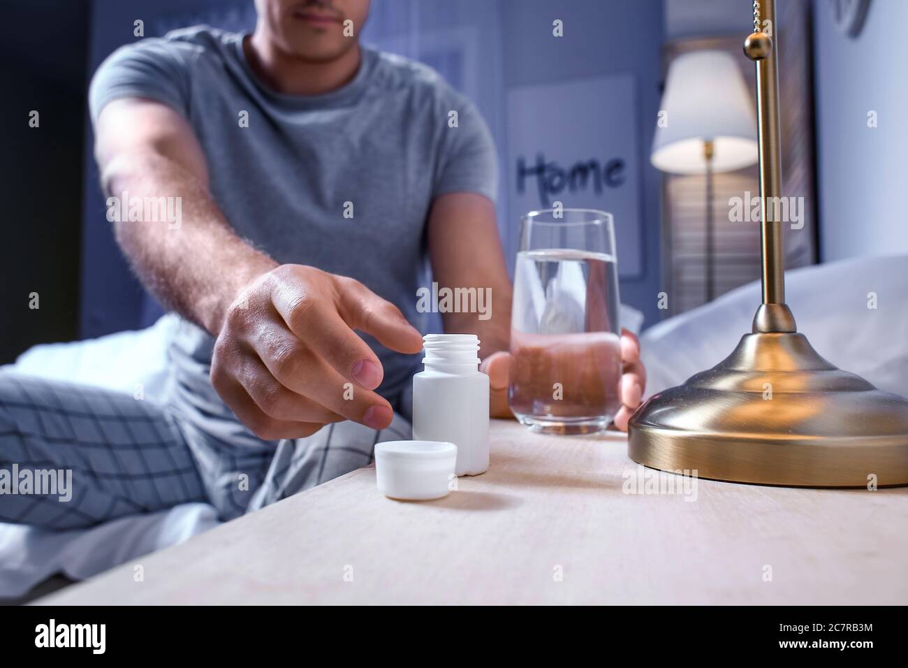 Young man taking sleeping pills at night Stock Photo Alamy