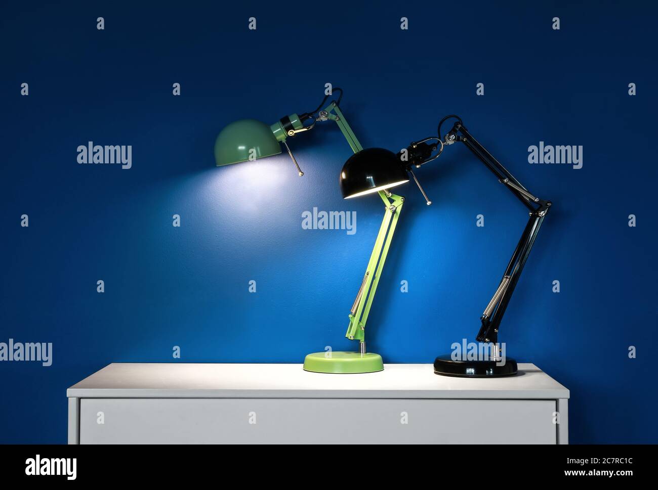 Chest of drawers with glowing lamps in room Stock Photo Alamy