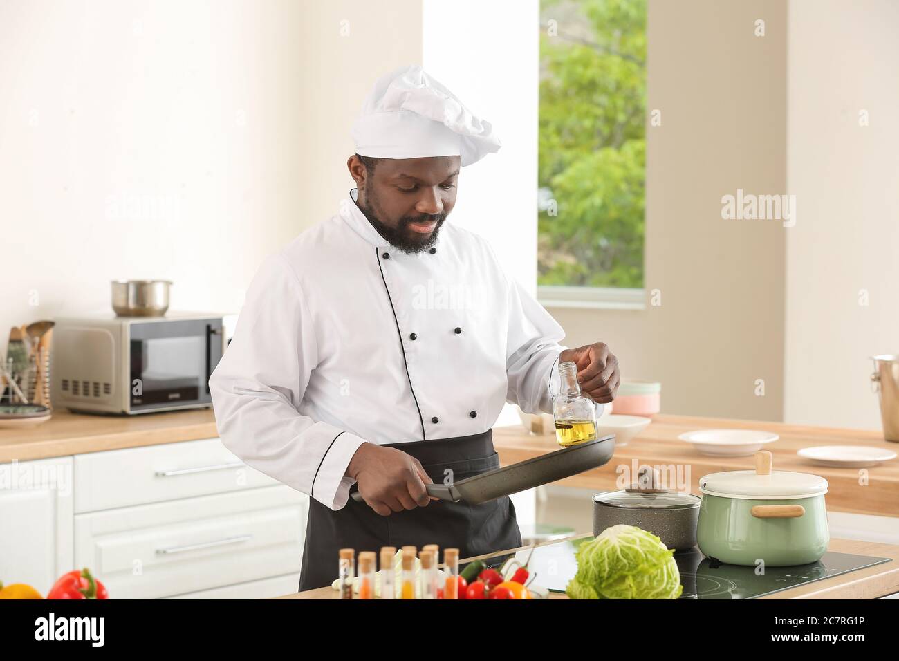 Male African-American chef cooking in kitchen Stock Photo - Alamy