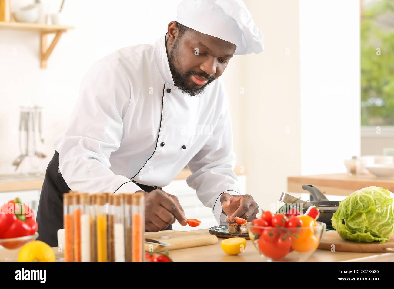 Male African-American chef cooking in kitchen Stock Photo