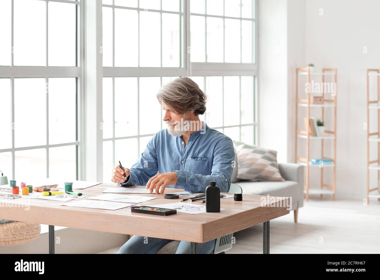 Senior male calligraphist working in office Stock Photo