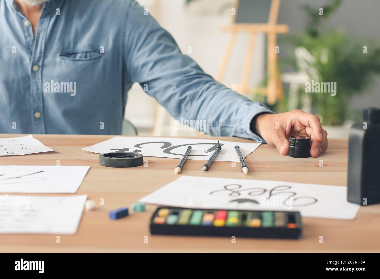 Senior male calligraphist working in office Stock Photo