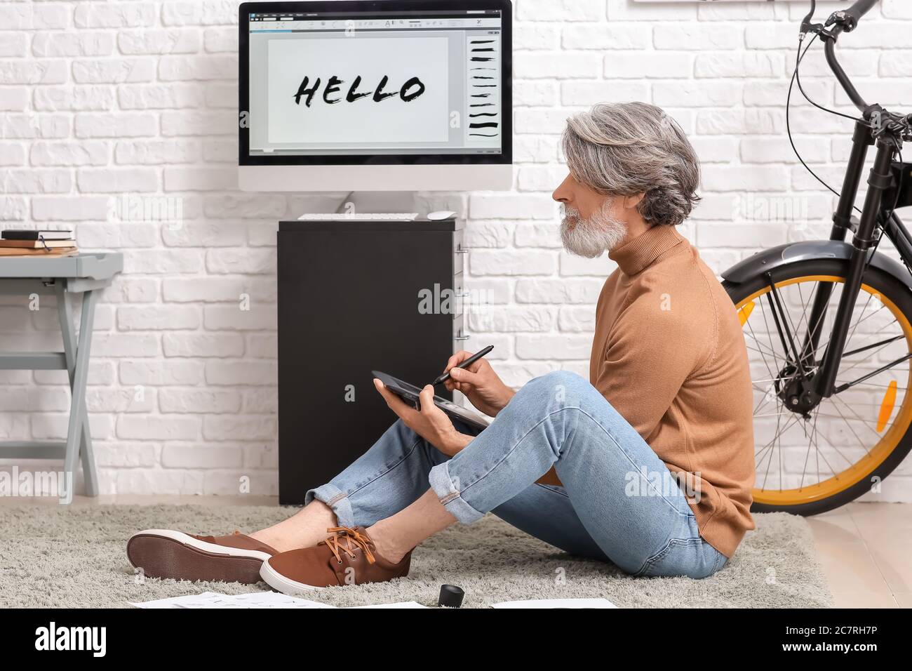 Senior male calligraphist working in office Stock Photo