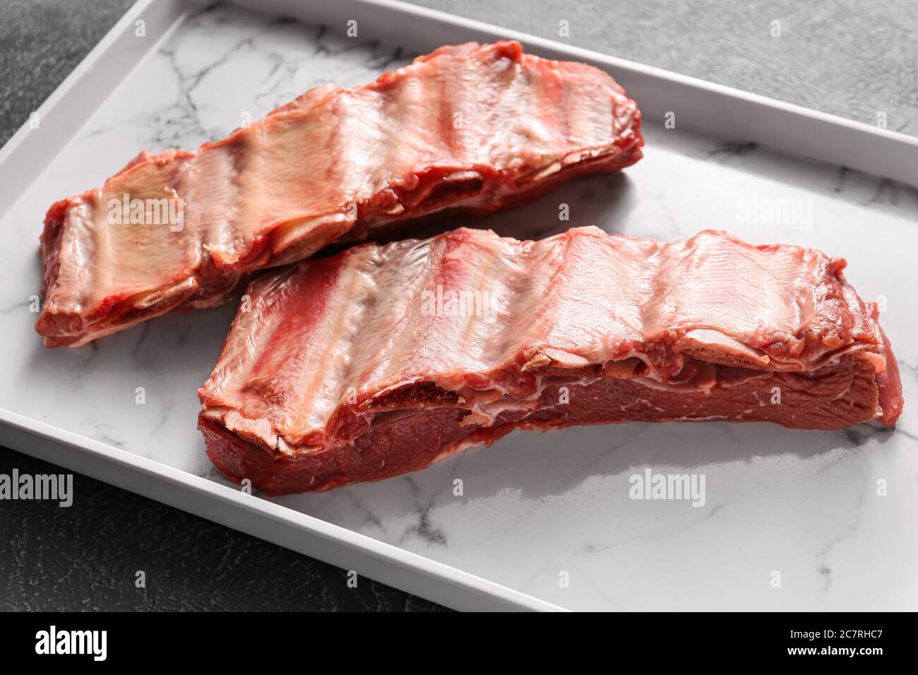 Raw beef short ribs on plate, closeup Stock Photo - Alamy