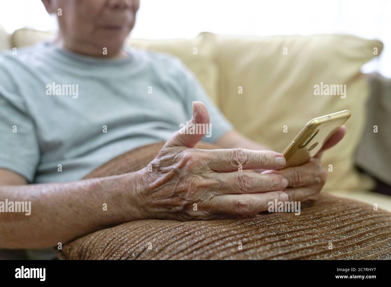 Elderly asian man reading his cellphone. Tech savvy in his 80s. Stock Photo