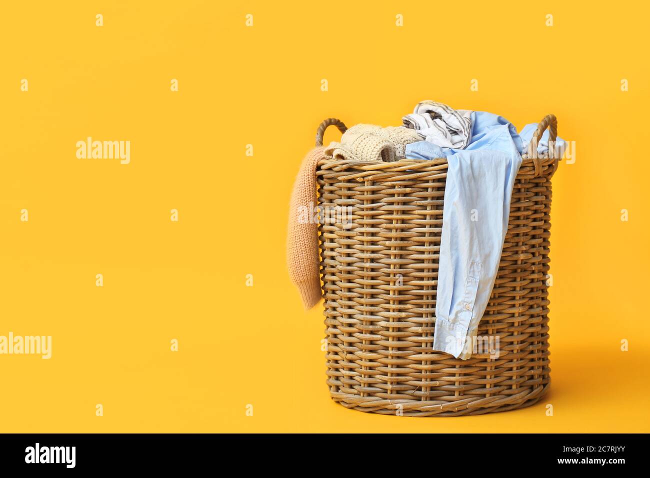 Basket with dirty clothes on color background Stock Photo