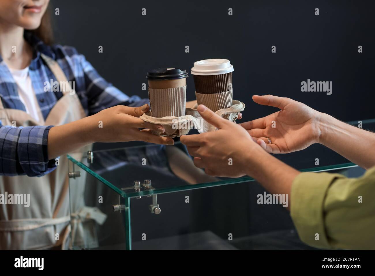 Barista giving client tasty coffee in modern cafe Stock Photo - Alamy