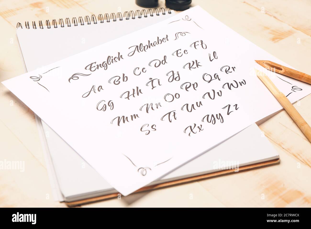 Notebook and paper sheet with alphabet on table Stock Photo