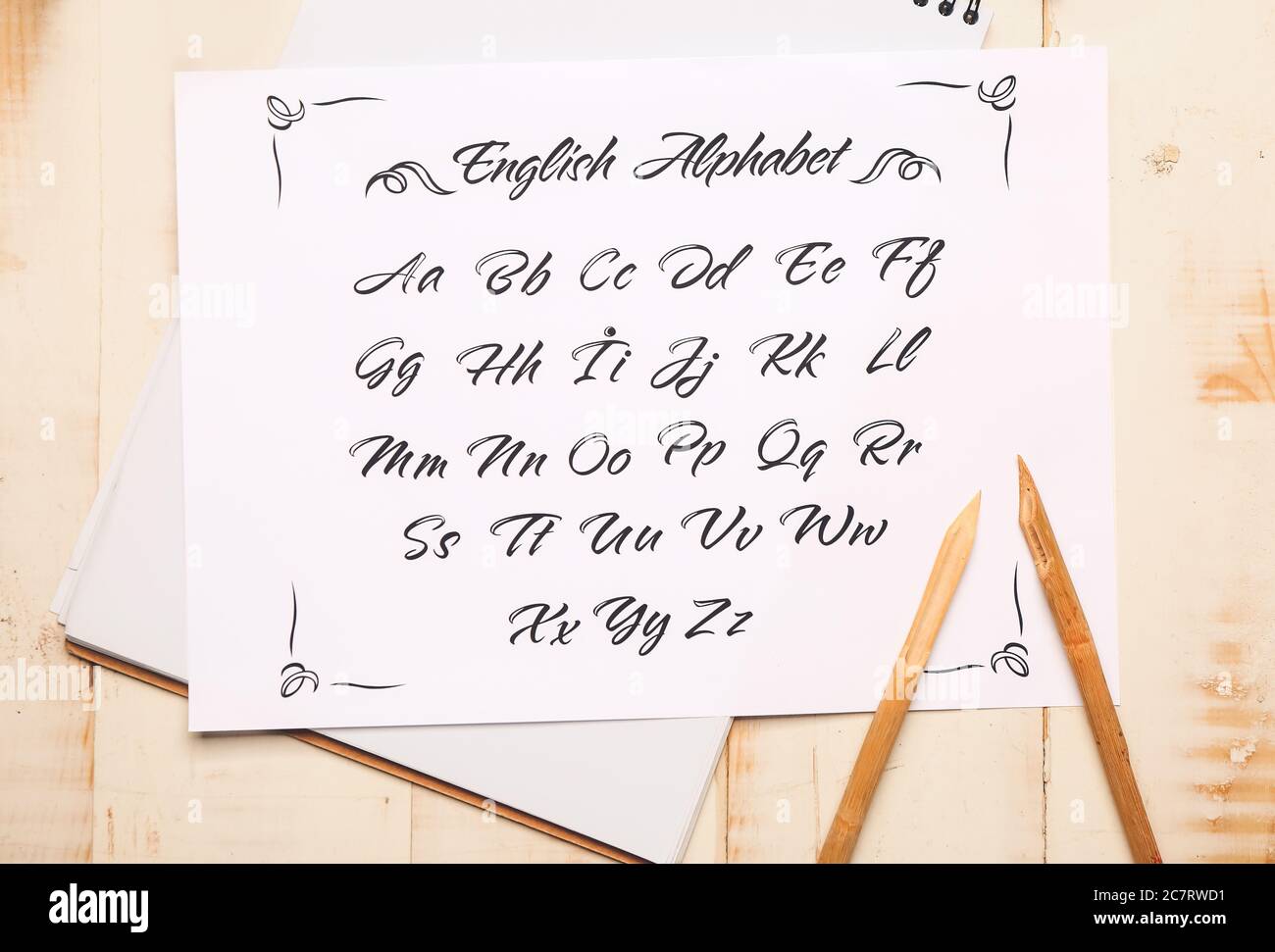 Notebook and paper sheet with alphabet on table Stock Photo