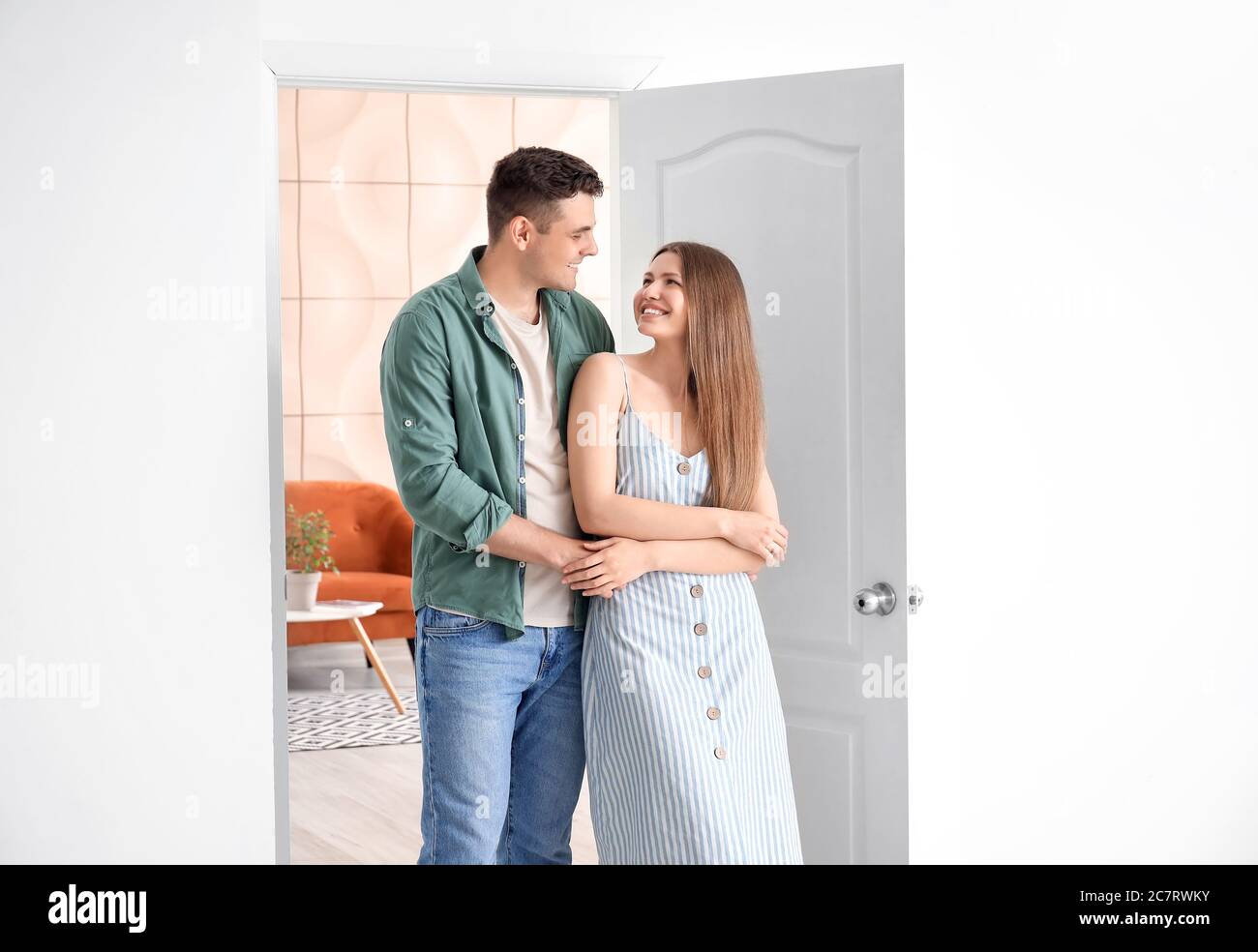 Happy couple in front of door at their new home Stock Photo - Alamy