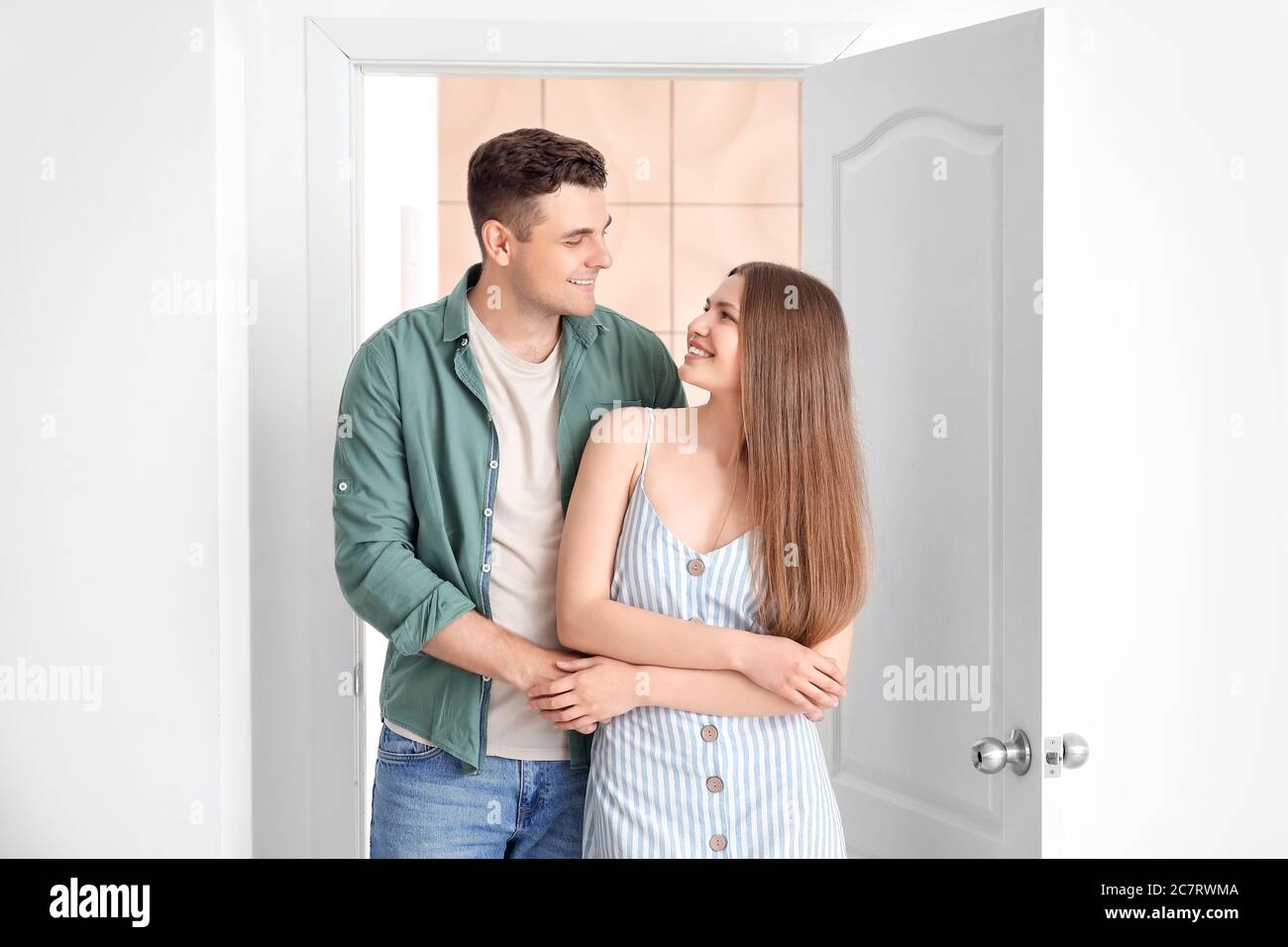 Happy couple in front of door at their new home Stock Photo - Alamy